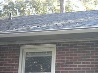 ST9 Snow Guards above doorway on asphalt shingle roof - close-up